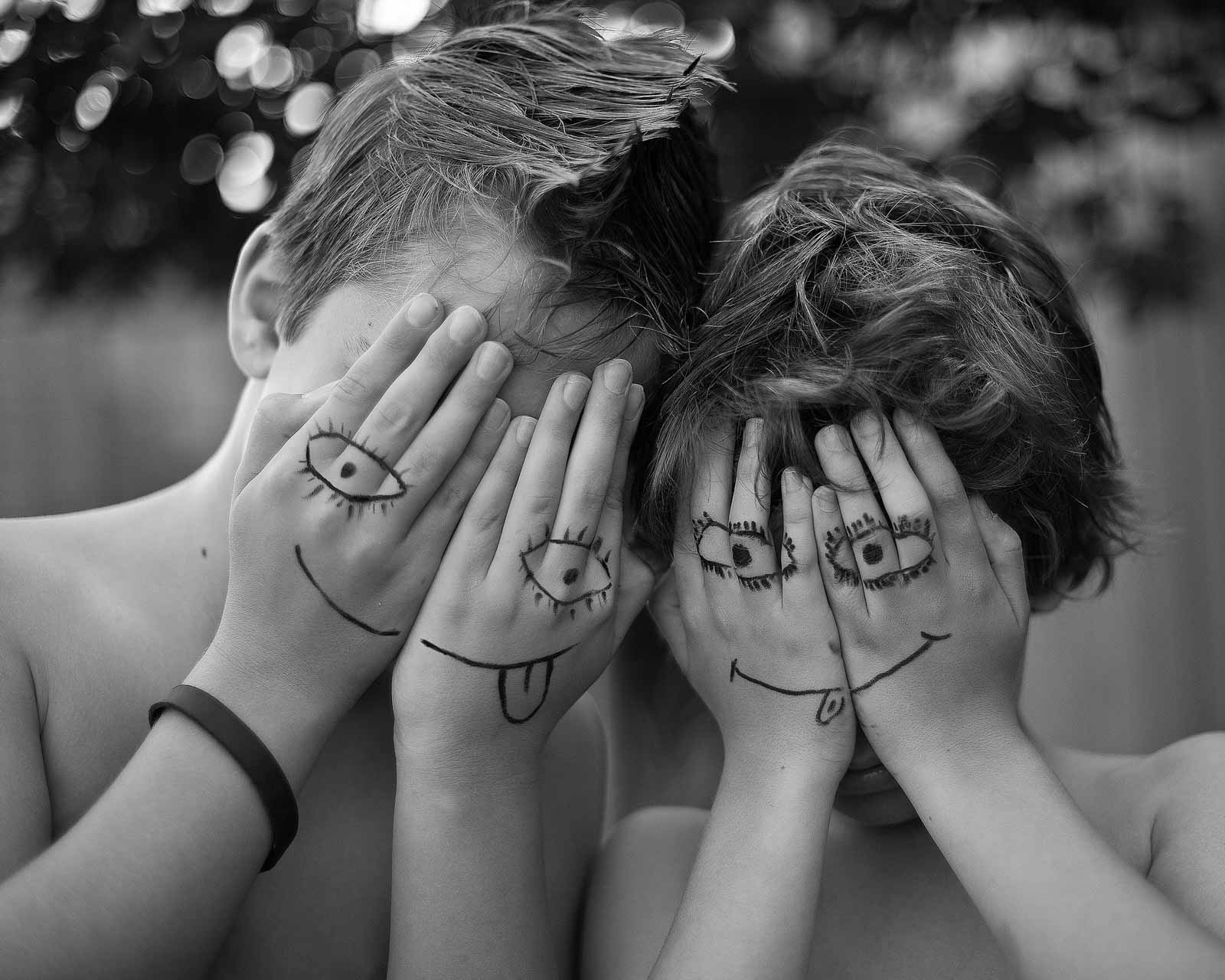 Dzieci zakrywające twarz pomalowanymi rękoma